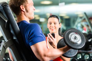 A personal trainer helping a man working out