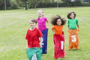 Four multiracial children in potato sack race